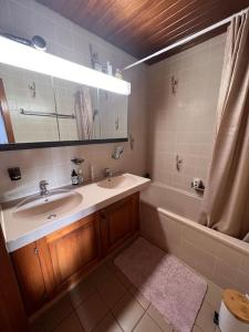 PullyにあるAppartement spacieux à Lausanneの洗面台、浴槽、鏡のあるバスルーム