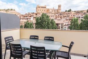 a table and chairs on a balcony with a city at Casa Tío Pepe Valderrobres in Valderrobres