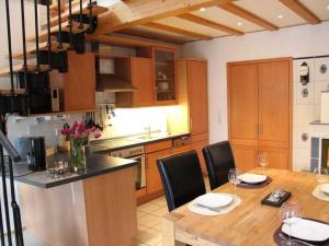 a kitchen with a table and chairs and a kitchen with wooden cabinets at Winkelchen Comfortable holiday residence in Cochem +17 photos