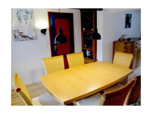 a wooden table and chairs in a living room at Midgard Comfortable holiday residence in Nieby