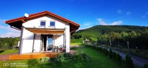 a small white house in a field of grass at JAWORNICA HOUSE domek z pięknym widokiem in Targanice +41 photos