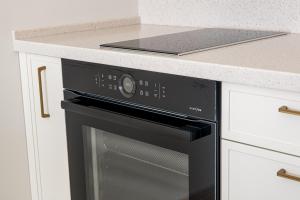 a black oven in a kitchen with a counter at Vanagupės Perlas in Palanga +4 photos