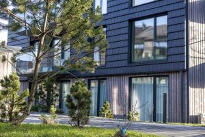 a black house with a tree in front of it at Vanagupės Perlas in Palanga