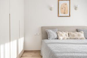 a bedroom with a bed and a picture on the wall at Vanagupės Perlas in Palanga