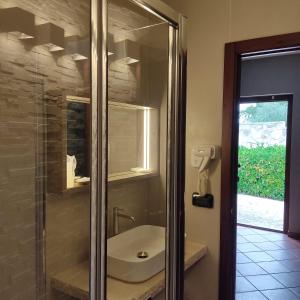a bathroom with a sink and a glass shower at Maglioferro Residence in Corato