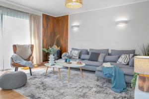 a living room with a blue couch and a table at Ferienhaus Seerose - Sauna, eingezäunter Garten, Hunde, 3 min zum See in Göhren-Lebbin