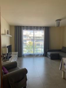 a living room with a couch and a large window at Apartamento Augusta Cambrils Lux con vista al mar in Cambrils