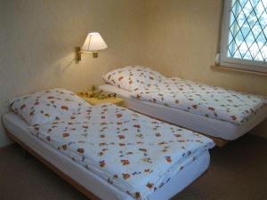 two twin beds in a room with a lamp at Lüchinger in Arbon