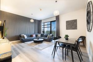 シャルジャにある2Bedroom Apartment - Uptown Al Zahia, Sharjah - Stone Houseのソファとテーブルのあるリビングルーム