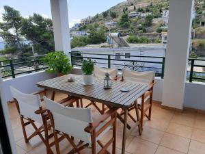 a wooden table and chairs on a balcony at Meto Rooms in Sarandë