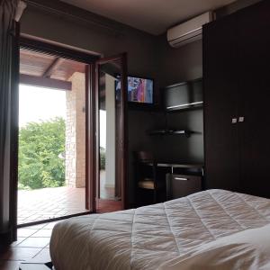 a bedroom with a bed and a sliding glass door at Maglioferro Residence in Corato