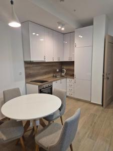 a kitchen with a white table and chairs at Rafailovici Beachfront Apartment 2 in Budva