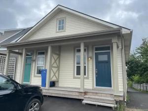 a small white house with a blue door at Modern apartment - 1 Bed in Caraquet