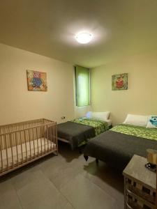 a room with two beds and a crib in it at Apartamento Augusta Cambrils Lux con vista al mar in Cambrils +20 photos