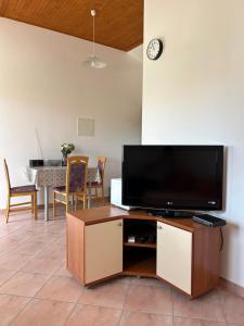 a living room with a television and a table with chairs at Apartments Anka Brala in Posedarje
