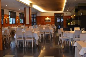a dining room with white tables and white chairs at Hotel Elorrio in Elorrio