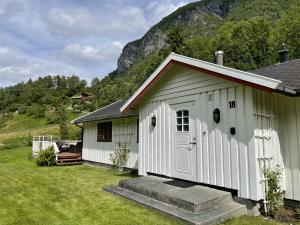 a white building with a porch and a house at Dalhus - House with jacuzzi in Norddal