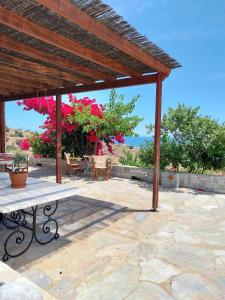 a wooden pergola with a bench on a stone patio at Villa Tsonima in Agia Marina Mikrolimanou +34 photos