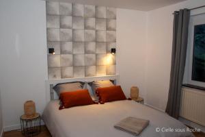 a bedroom with a white bed with two orange pillows at Cielle sous Roche in La-Roche-en-Ardenne