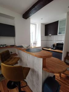 a kitchen with two bar stools and a counter top at Fourdray in Cherbourg en Cotentin +9 photos