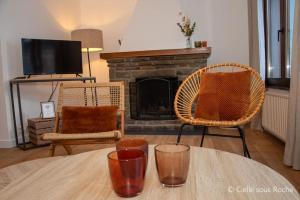 a living room with a table with two chairs and a fireplace at Cielle sous Roche in La-Roche-en-Ardenne