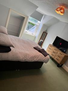 a bedroom with a bed and a flat screen tv at 4 bed Harbour House in Wick