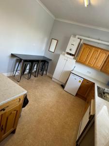 an empty kitchen with two tables and a counter at 4 bed Harbour House in Wick