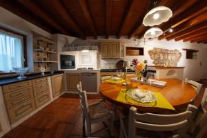 a kitchen with a wooden table and a dining room at La Valle dei Laghi in Revine Lago