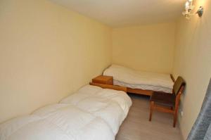 a small room with two beds and a chair at Landleben! Bungalow Feldblick 5 Personen in Blankensee