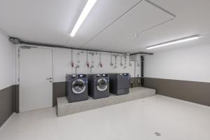 a laundry room with three washing machines in it at Beaufort Sailors' Park - tot 6 personen - incl garage in Nieuwpoort