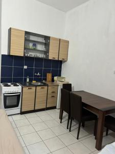 una cucina con tavolo, piano cottura e armadietti di Apartman Drazen Rafailovici a Rafailovici