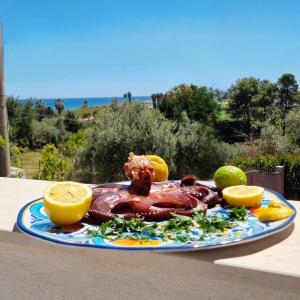 a plate of food on a table with oranges at Ca' Libellula Casa Vacanza in Avola