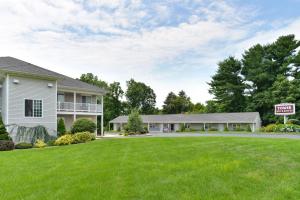 uma casa com um sinal de venda num quintal em Tower Inn and Suites of Guilford / Madison em Guilford