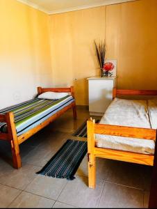 una camera con due letti, un tavolo e un tappeto di Mbotyi Mnceba cottage a Lusikisiki