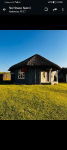 una piccola casa in un campo erboso di Mbotyi Mnceba cottage a Lusikisiki