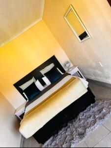 una camera con un grande letto e una parete gialla di Mbotyi Mnceba cottage a Lusikisiki Altre 11 foto