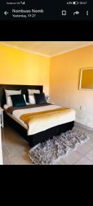 una camera da letto con un grande letto con pareti gialle di Mbotyi Mnceba cottage a Lusikisiki