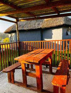 un tavolo da picnic in legno e una panca sotto un tetto di paglia di Mbotyi Mnceba cottage a Lusikisiki