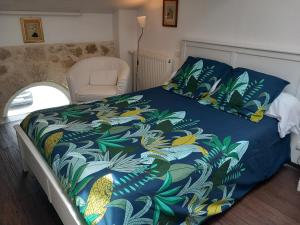 a bed with a blue comforter and a chair at Chambres D'Hôtes Saint Jean in Saint-Jean-de-Blaignac