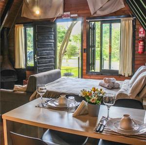 ein Esszimmer mit Tisch und Stühlen sowie Weingläsern in der Unterkunft Mon Chalet in Praia Grande