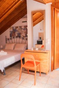 a bedroom with a bed and a desk and a chair at Villa Sissy Studios & Apartments in Syvota