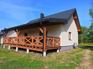 a small house with a black roof at Ostoja nad Gilem in Ostrów Wielki