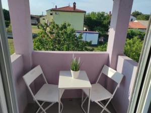 a small white table and chairs on a balcony at Crystal Apartment Umag in Umag
