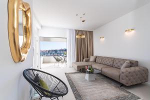 a living room with a couch and a table and chairs at Villa Sunset Dubrovnik in Dubrovnik