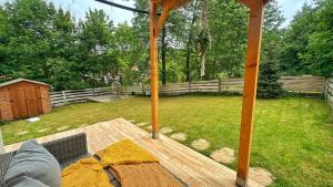 a backyard with a wooden deck with a fence at Stylowy Apartament w sercu Uzdrowiska in Jedlina-Zdrój