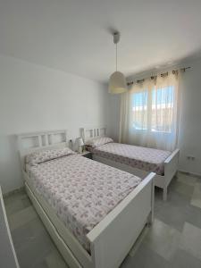 Un dormitorio blanco con dos camas y una ventana. en a 600 m de la playa y el castillo santa ana, en Roquetas de Mar 39 fotos más