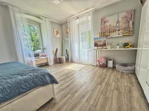 a bedroom with a bed and a wooden floor at Stylowy Apartament w sercu Uzdrowiska in Jedlina-Zdrój