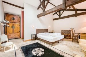 a bedroom with a bed and a table and chairs at Chateau de la Vieille Chapelle in Lugon et l’Ile du Carney