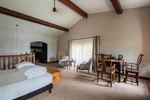 a bedroom with a bed and a desk and chairs at Chateau de la Vieille Chapelle in Lugon et l’Ile du Carney