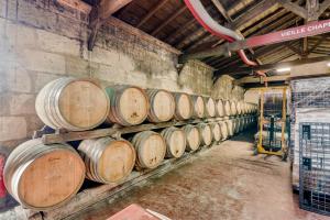 a row of wine barrels in a cellar at Chateau de la Vieille Chapelle in Lugon et l’Ile du Carney
